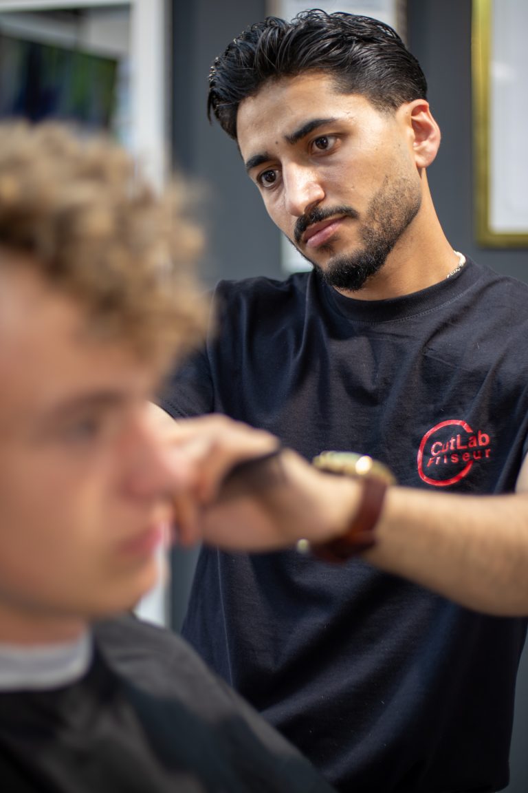 Friseurmeister konzentriert bei der Arbeit