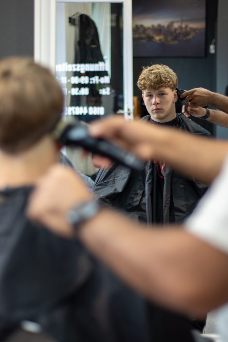 Haarschnitt im Spiegelbild des Salons